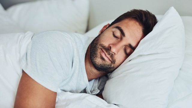 Homem dormindo em uma cama