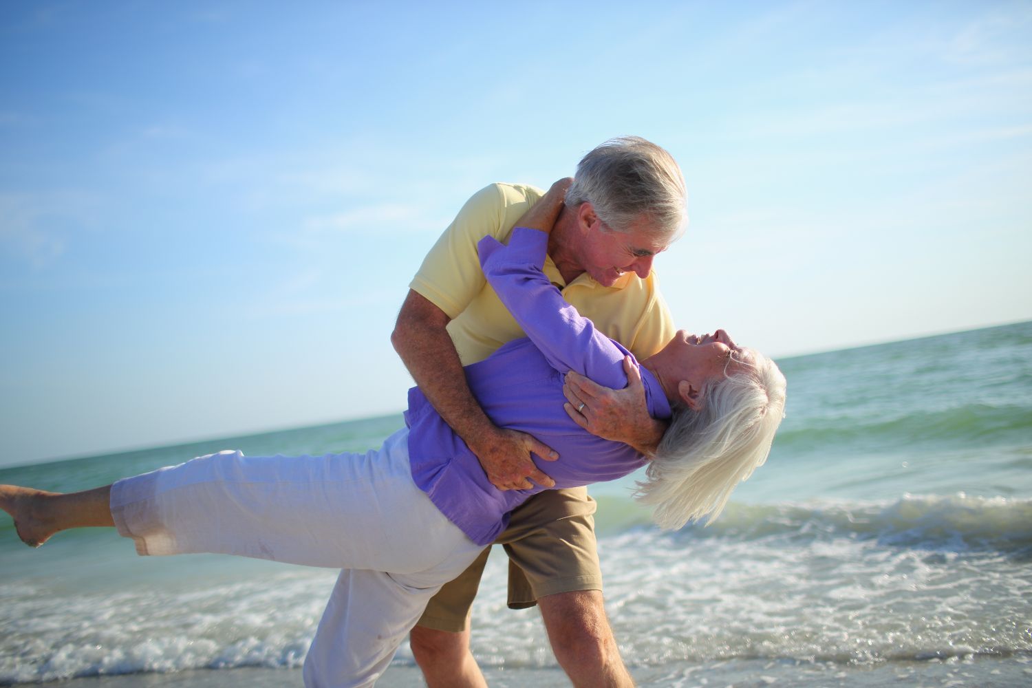 idosos dançando na praia